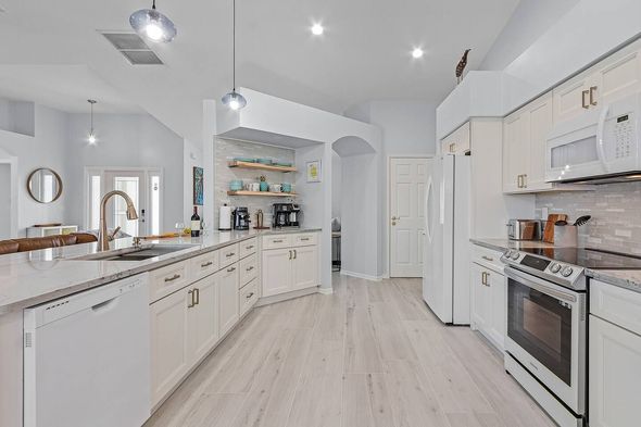 Image of a homeowner's kitchen after a recent renovation. All white walls & cabinets.