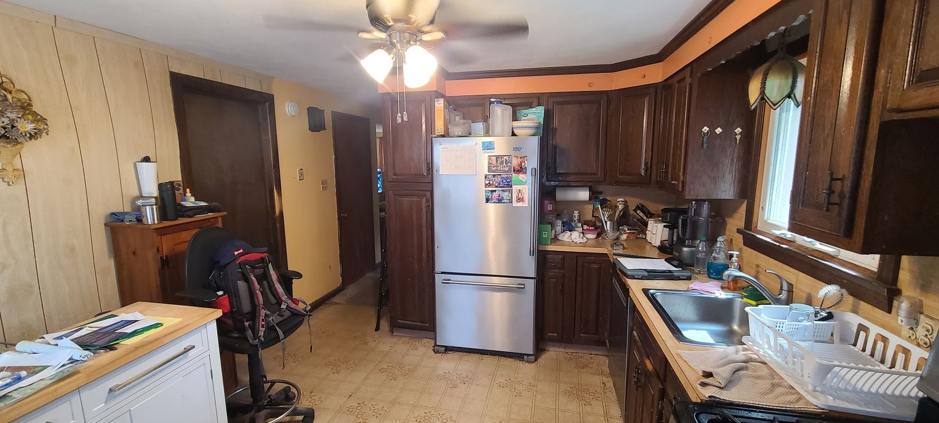 An image of a homeowner's kitchen before a renovation. Brown cabinets & tan countertops.
