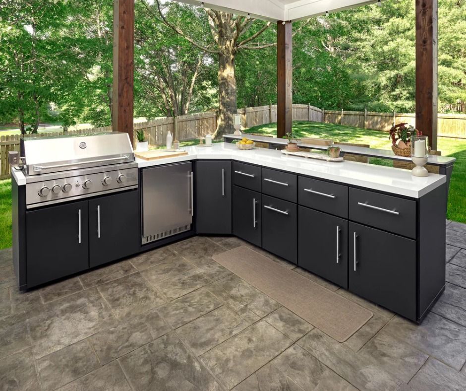 Image of a WeatherStrong outdoor kitchen set with black cabinets and white countertops complete with a grill.