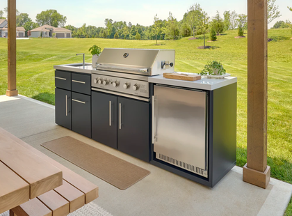 Outdoor kitchen with grill, sink, refrigerator, and dark gray cabinets.