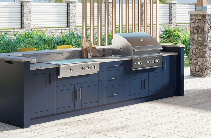 Outdoor kitchen with grill, sink, refrigerator, and dark gray cabinets.