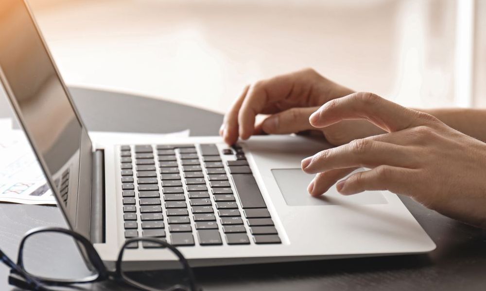 Someone typing on a laptop at a desk