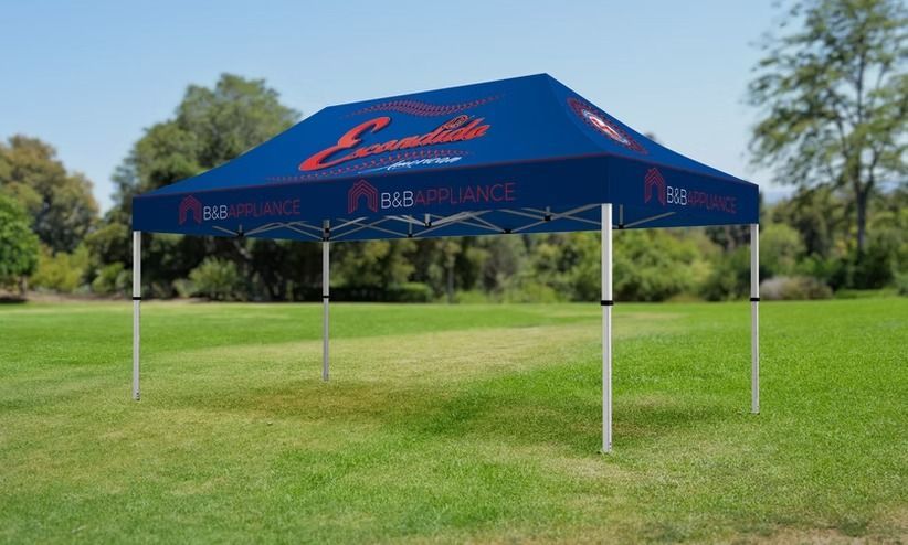 A blue canopy is sitting on top of a lush green field.
