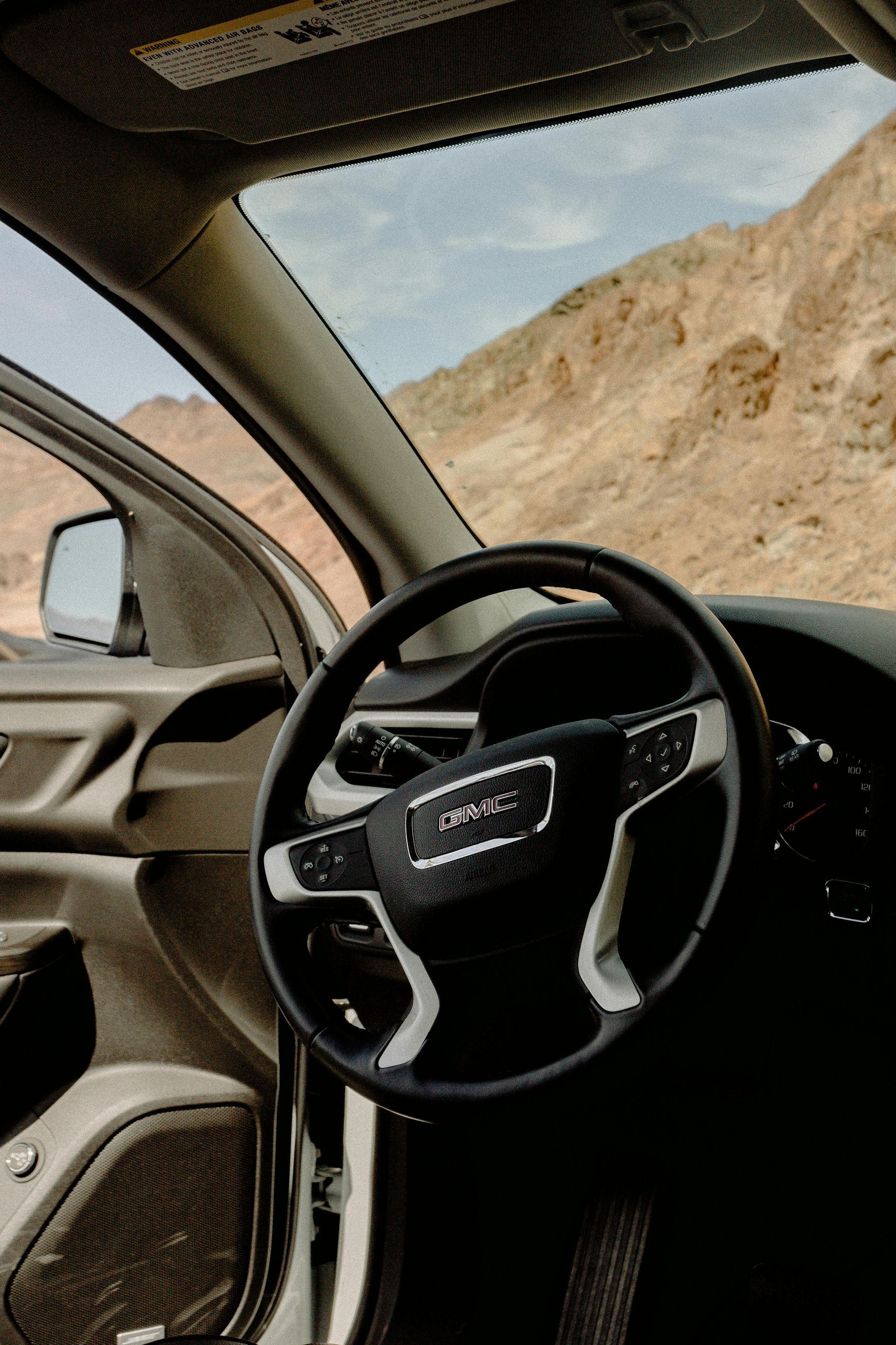 A close-up of a GMC steering wheel on a GMC vehicle from Macomb county that is off-roading. 