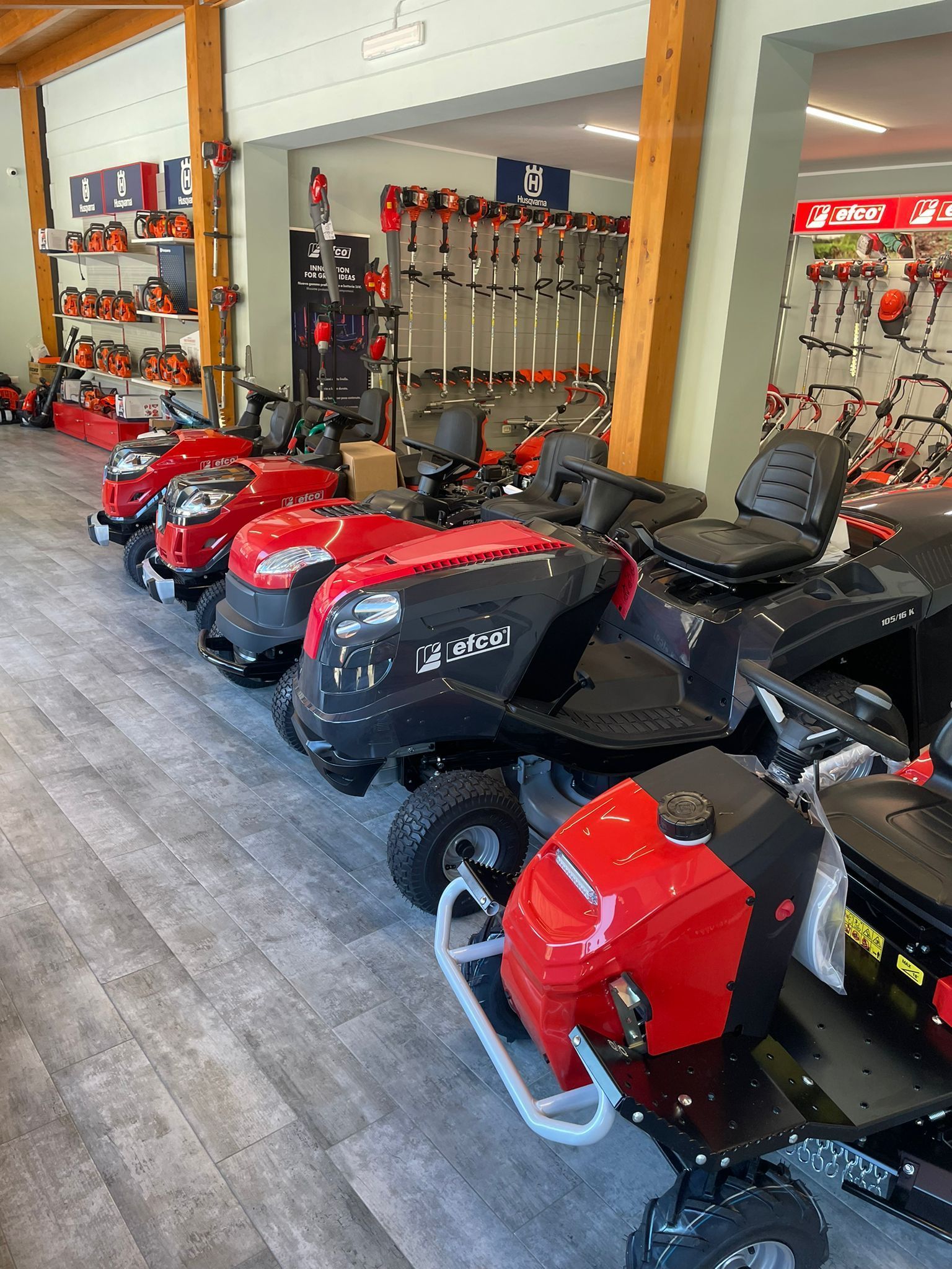 Una fila di motoslitte rosse e nere esposte all'interno di uno showroom o di un garage.
