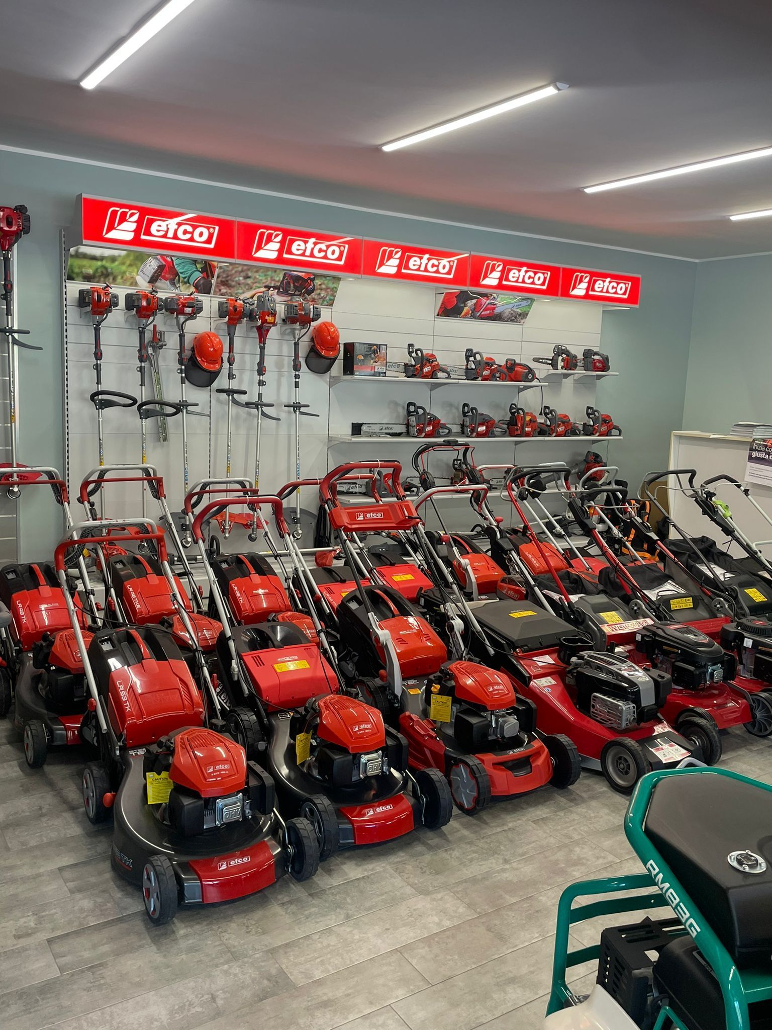 Showroom pieno di tosaerba e attrezzi da giardino rossi e neri in esposizione