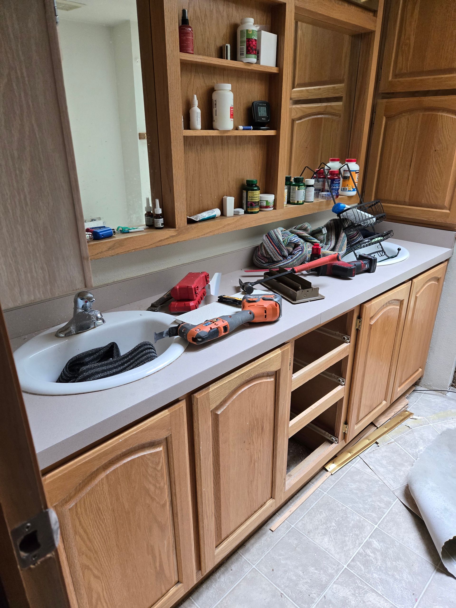 Kitchen counter covered with toy trucks and tools beside wooden cabinets and open shelves