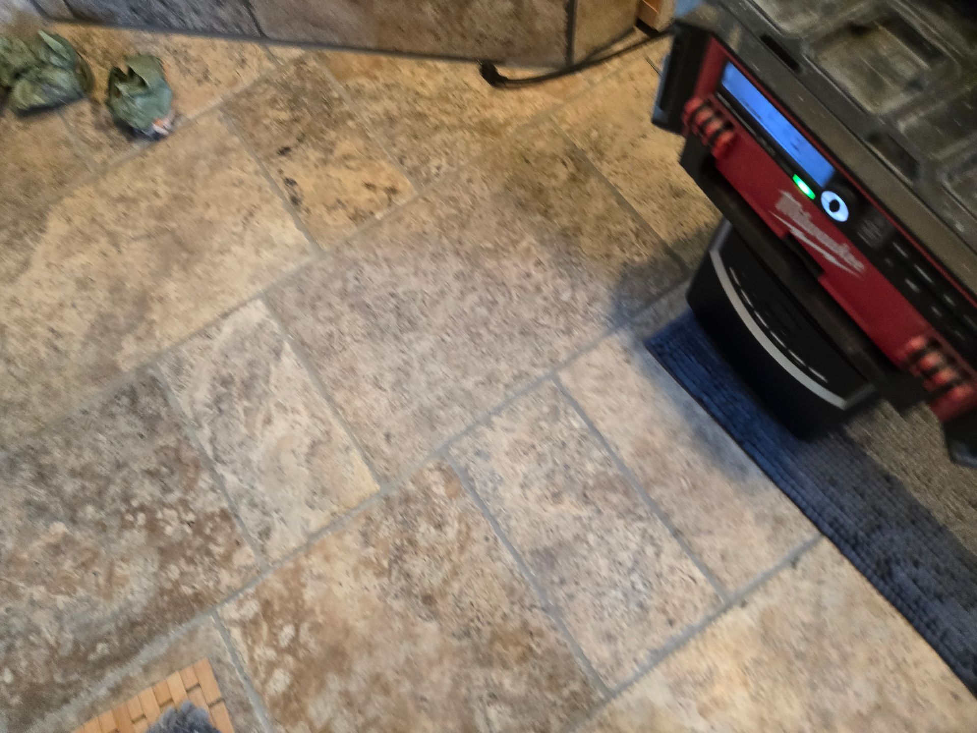 Tiled floor with a red vacuum cleaner on the right and a small pet toy or object near the top left.