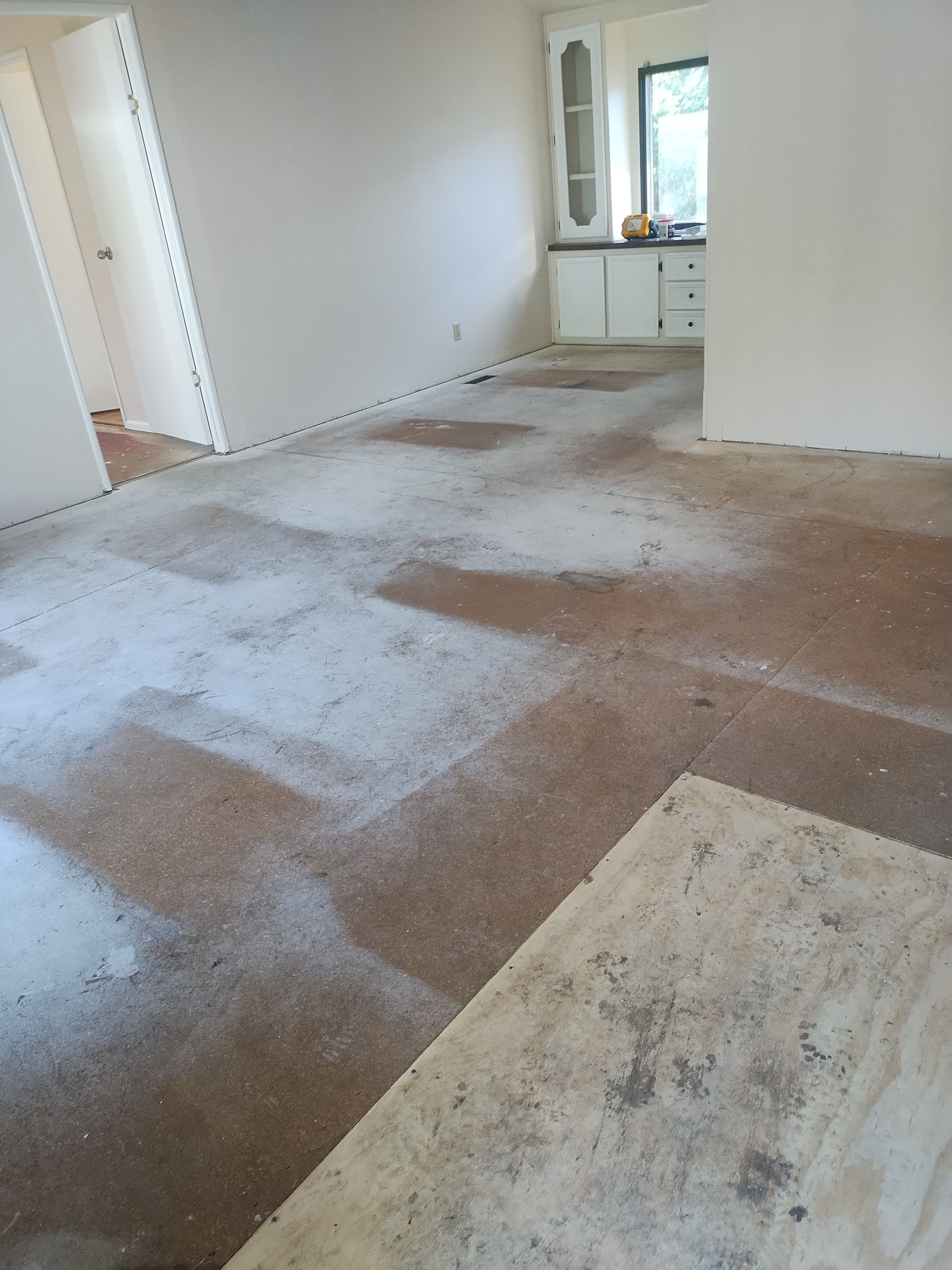 Empty room with worn carpet and white walls, seen from a doorway.