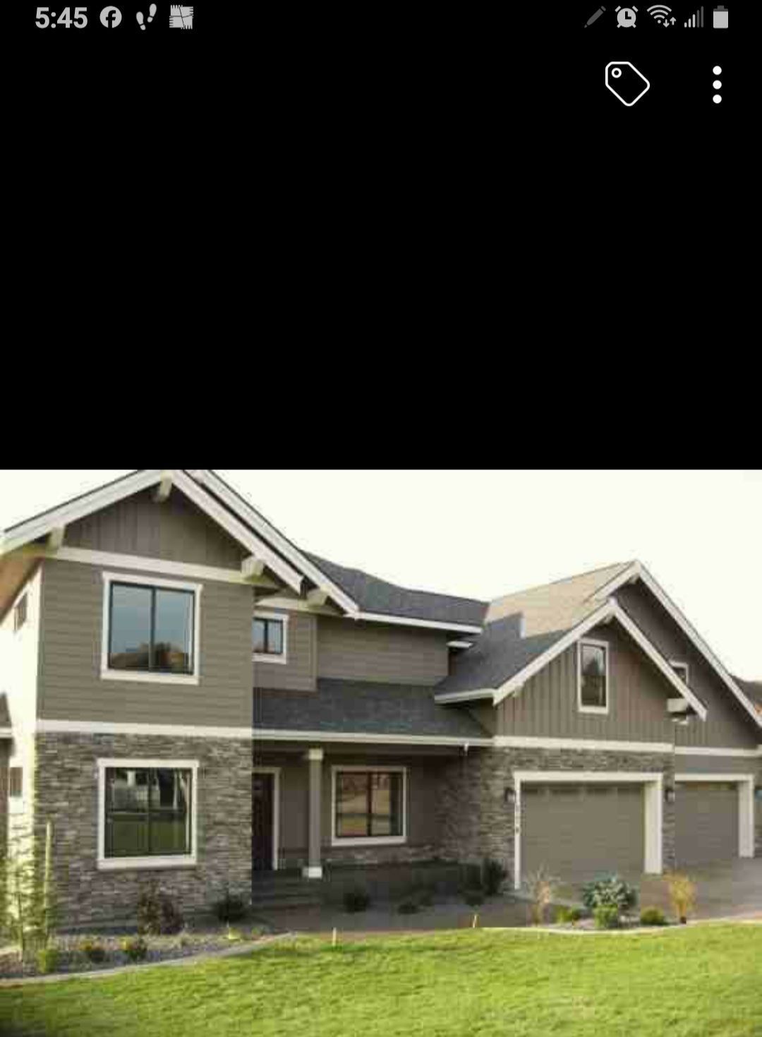 Two-story gray house with white trim, a front porch, and a double garage on a green lawn