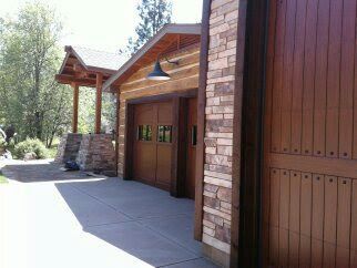 Modern wooden building exterior with stone columns and a covered entryway