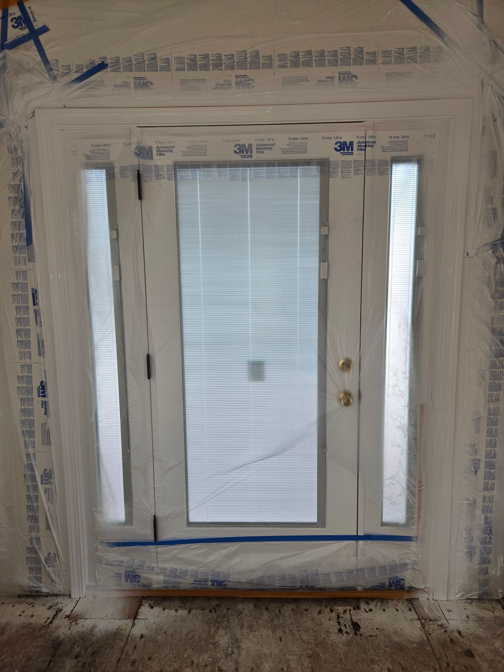 Painted white window frame with frosted glass and side panes, centered in a wall opening.