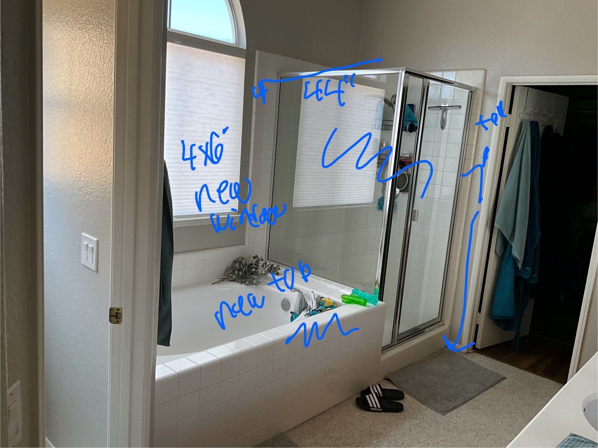 Bathroom with tub, shower, window, and door, blue writing annotations.