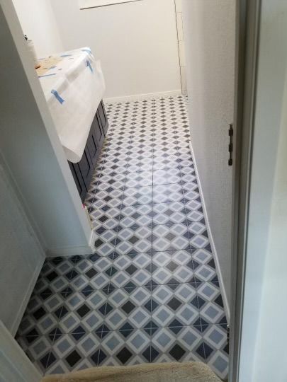 Hallway with patterned black, gray, and white diamond-shaped tile flooring.