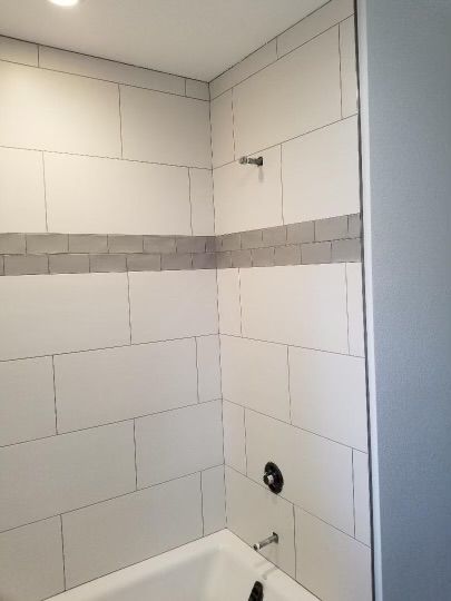 White kitchen with stainless steel appliances and dark countertops.