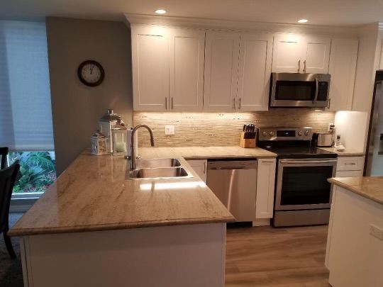 Kitchen with white cabinets, stainless steel appliances, and light countertops.