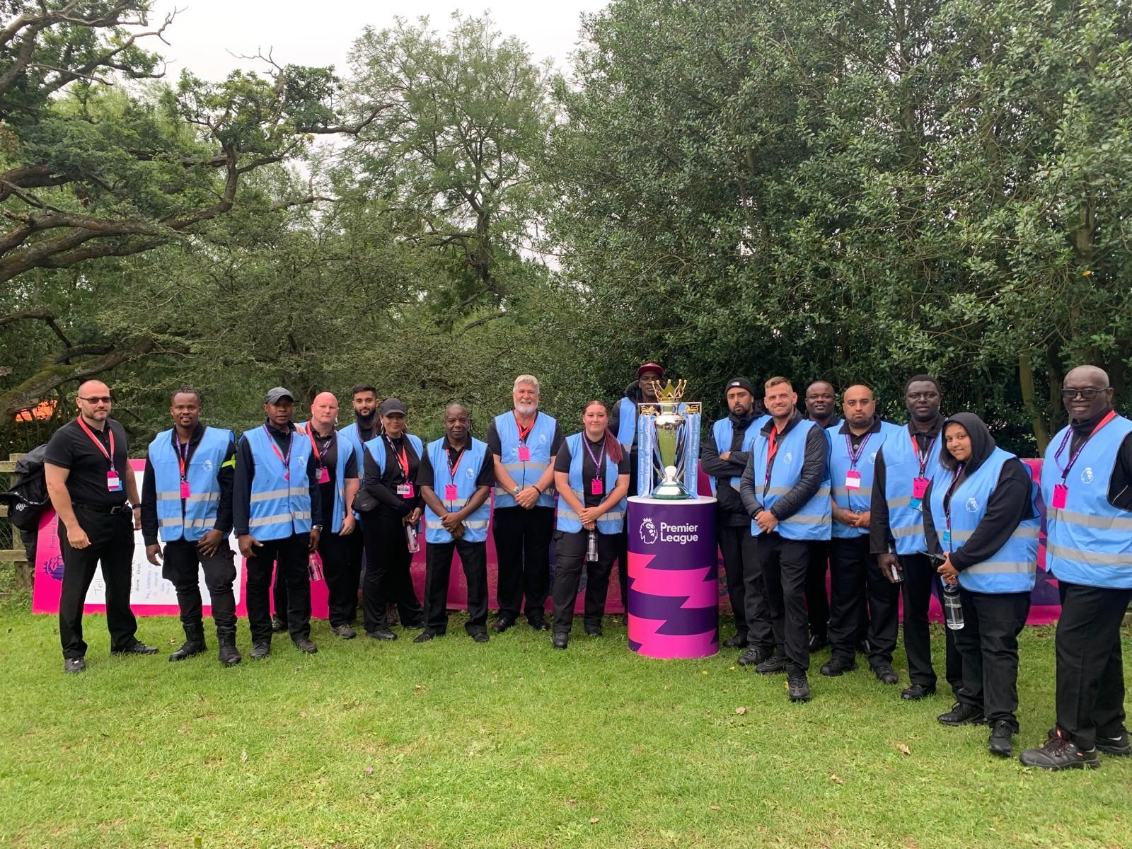 A group of people are standing in a field with a trophy.