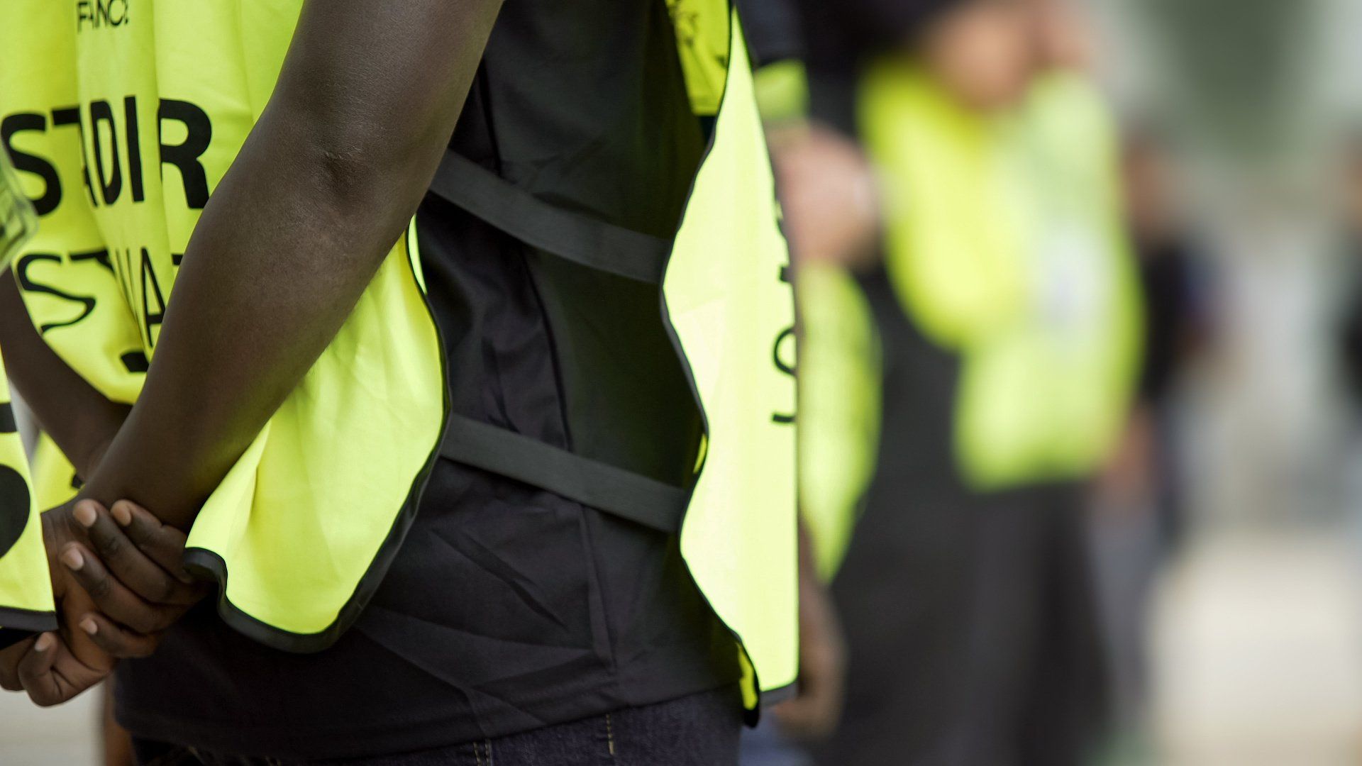 A person wearing a yellow vest that says sdr on it