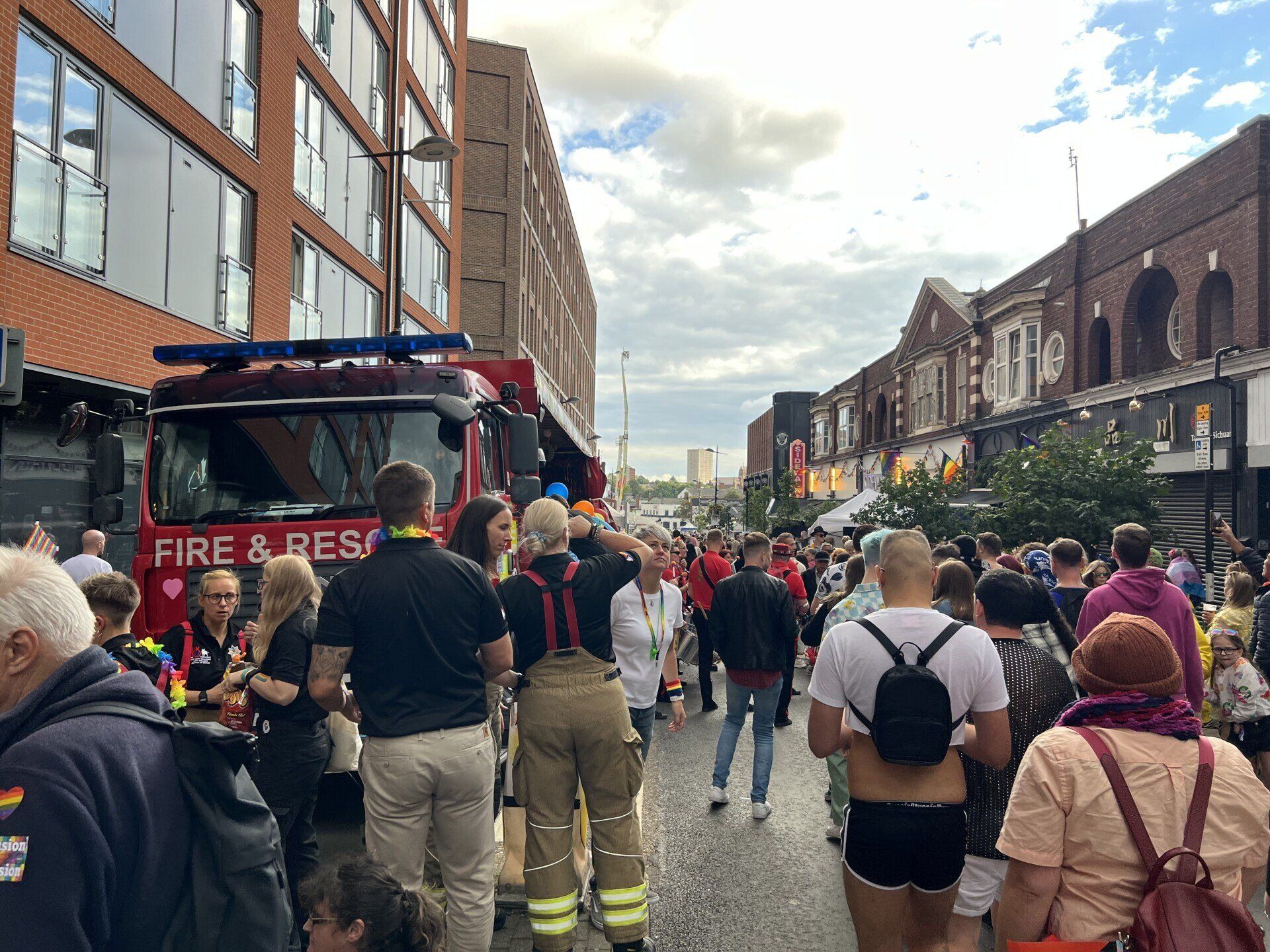 a crowd of people are standing in front of a fire truck .