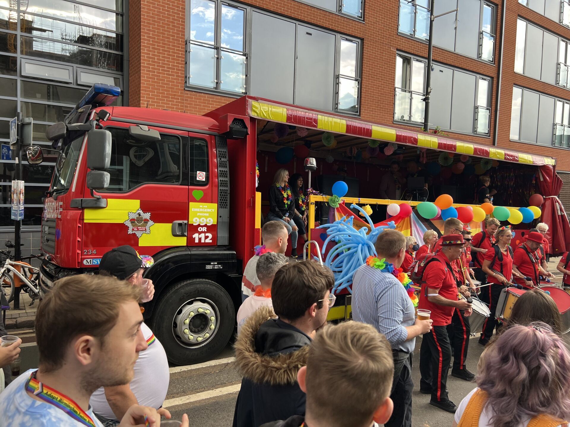 A group of people are standing in front of a fire truck.