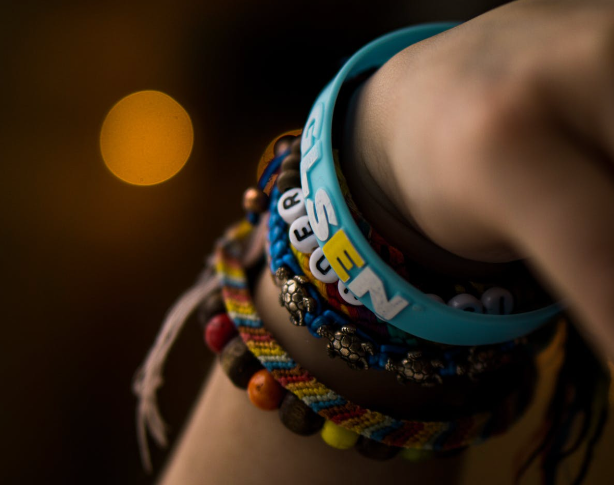 Different wrist bands on a female arm in a festival setting