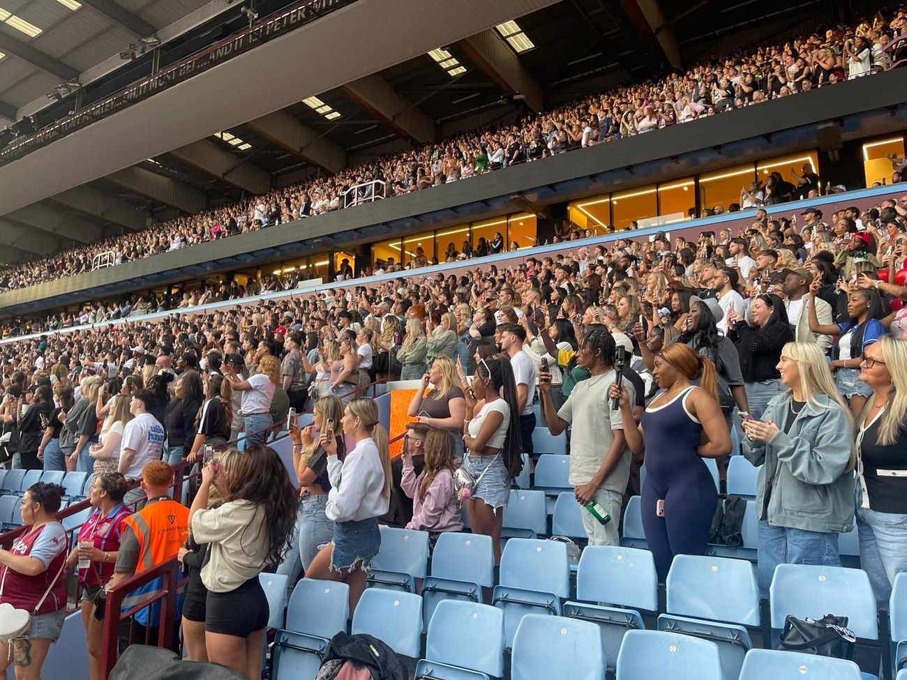 A crowd of people are sitting in a stadium watching a concert