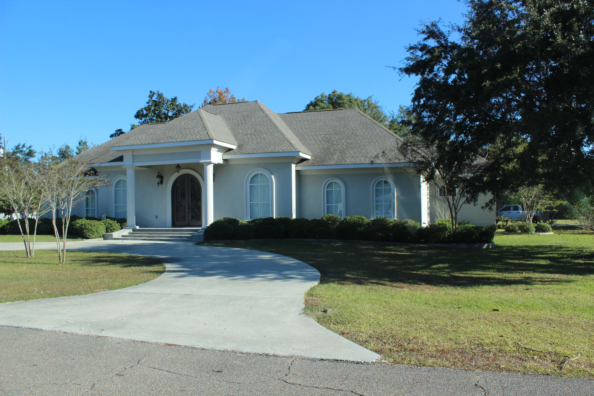 A large white house with a driveway leading to it