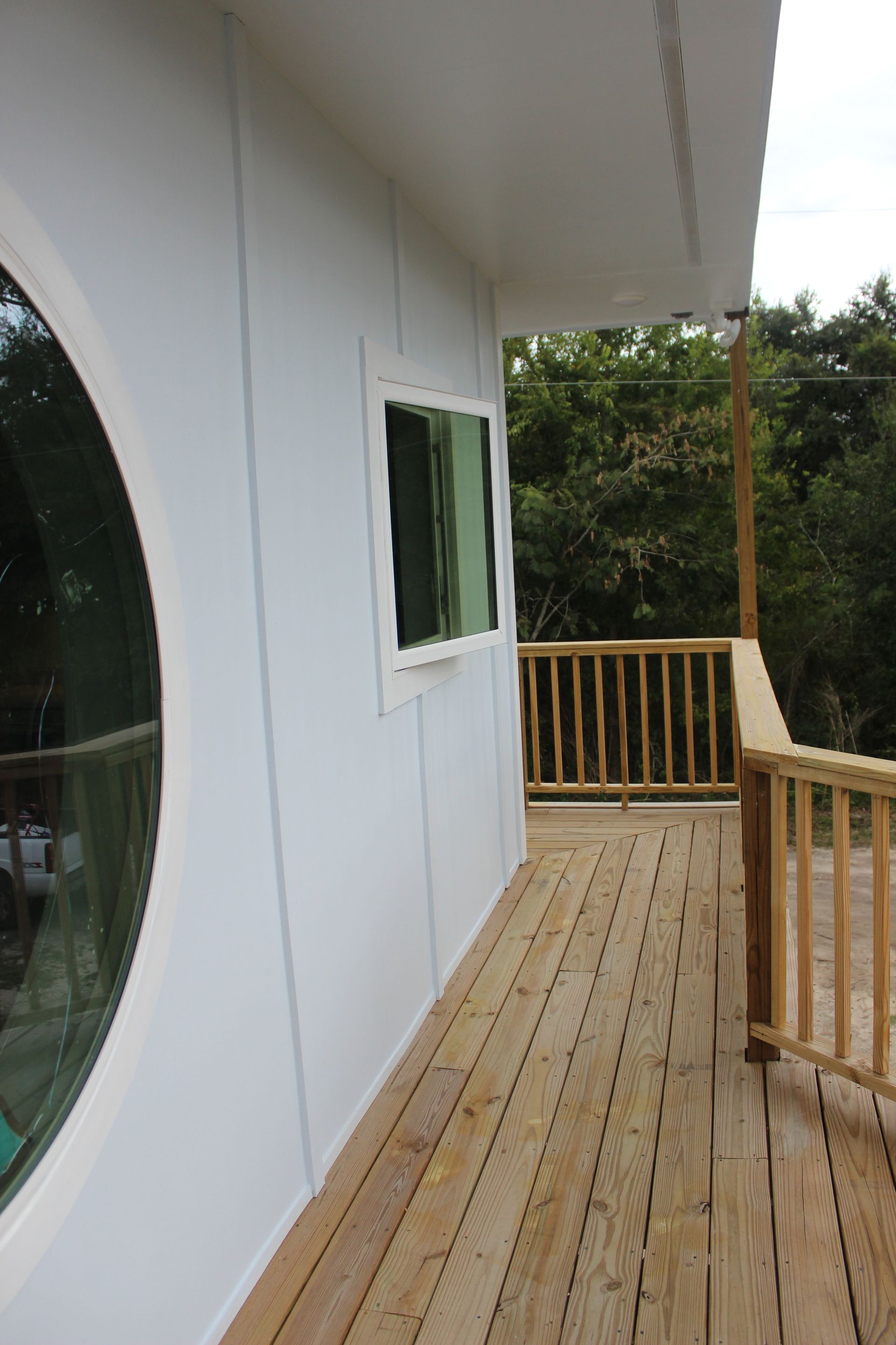 A white house with a wooden deck and a window