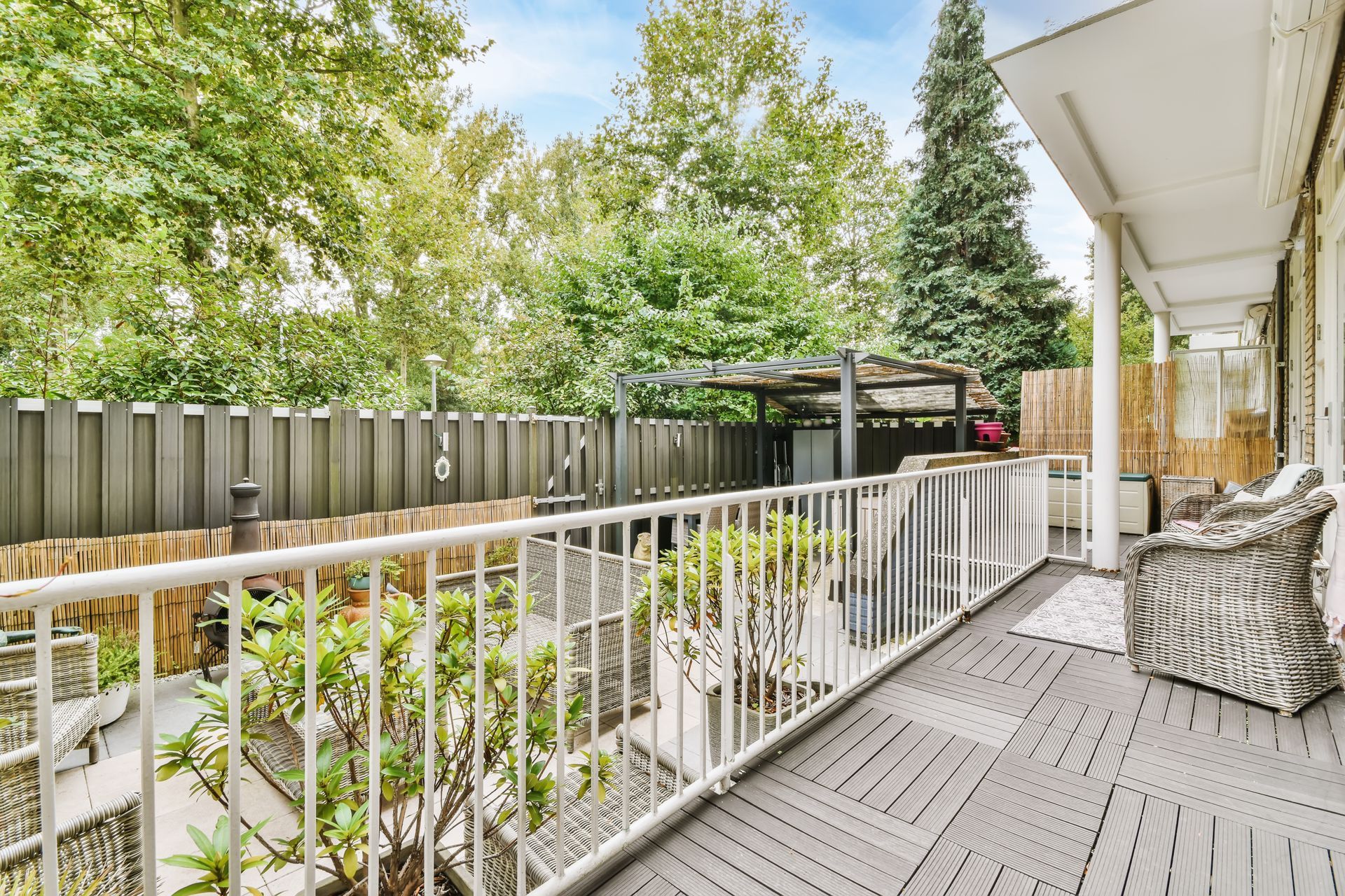 Composite deck with white railing and privacy fence installed in a residential backyard in the Ozark