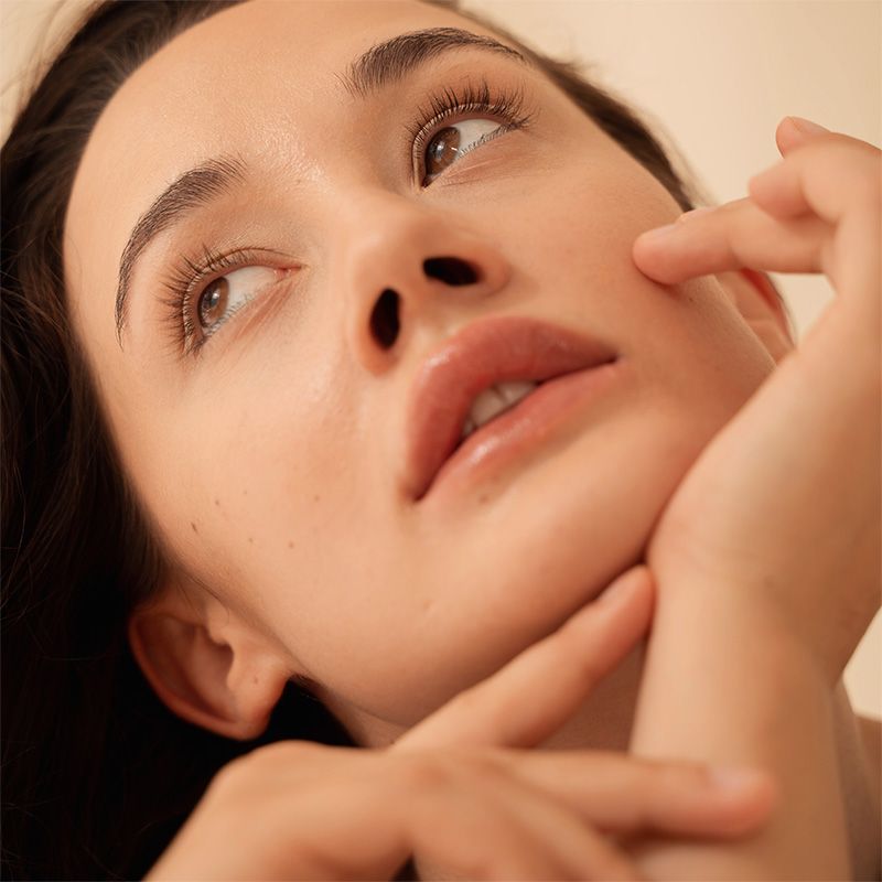 A close up of a woman 's face with her eyes closed.