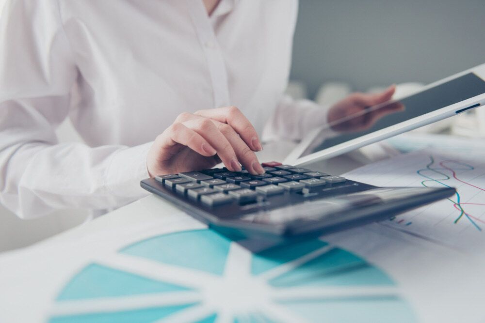 A Woman Is Using A Calculator And A Tablet At The Same Time — Visionary Accounting In Parkes, NSW