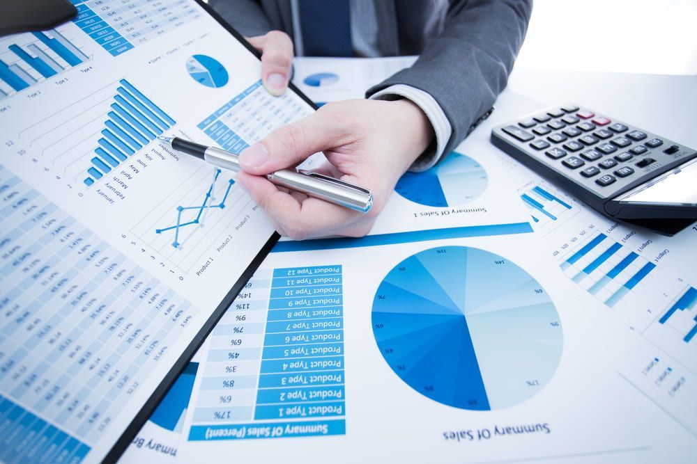 A Person Is Holding A Pen In Front Of A Calculator And A Clipboard — Visionary Accounting In Dubbo, NSW