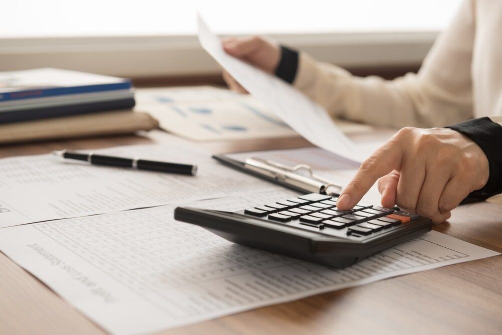 A Person Is Using A Calculator While Holding A Piece Of Paper — Visionary Accounting In Dubbo, NSW