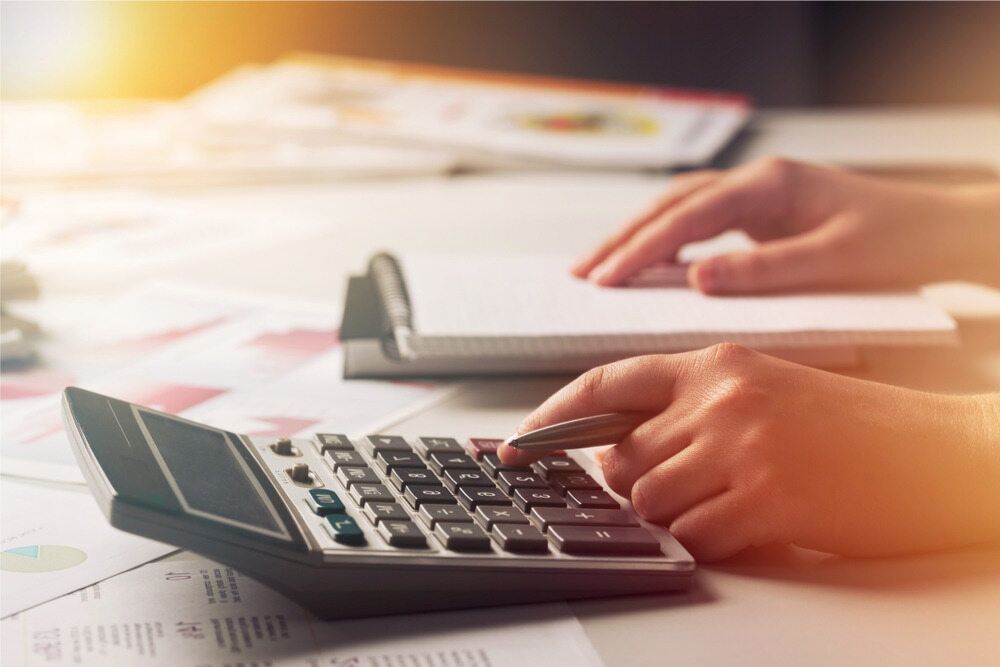 A Person Is Using A Calculator At A Desk — Visionary Accounting In Forbes, NSW