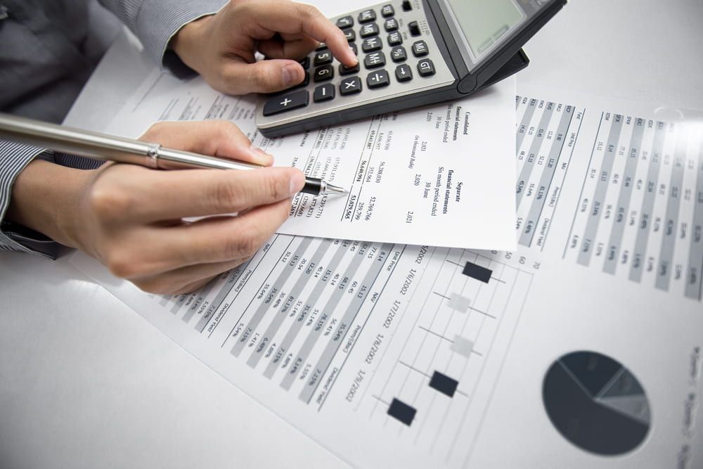 A Person Is Using A Calculator And Writing On A Piece Of Paper — Visionary Accounting In Dubbo, NSW