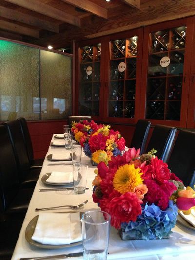 A long table with plates glasses and flowers on it
