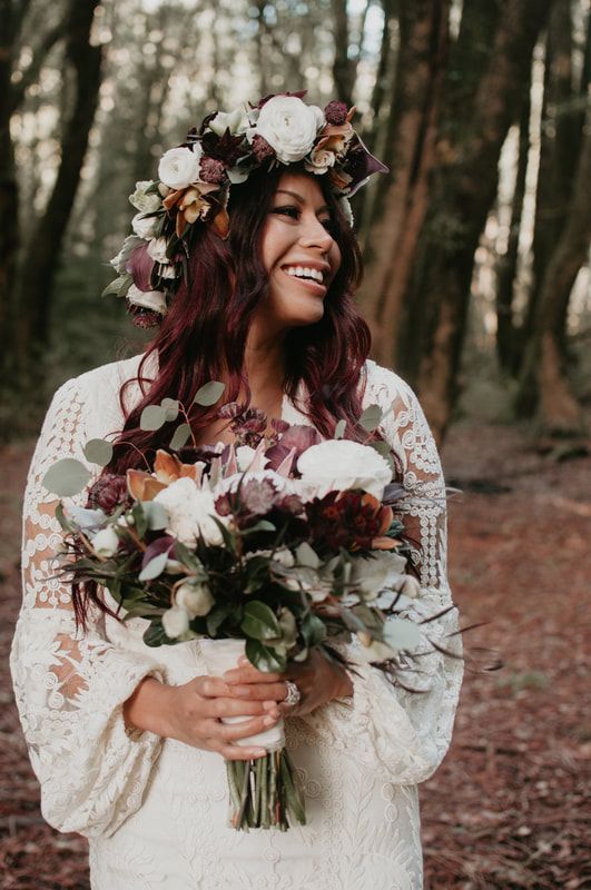 The bride is wearing a flower crown and holding a bouquet of flowers.