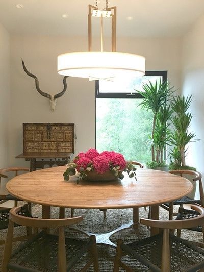 A dining room with a round wooden table and chairs