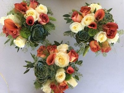 Three bouquets of flowers are sitting on a table.