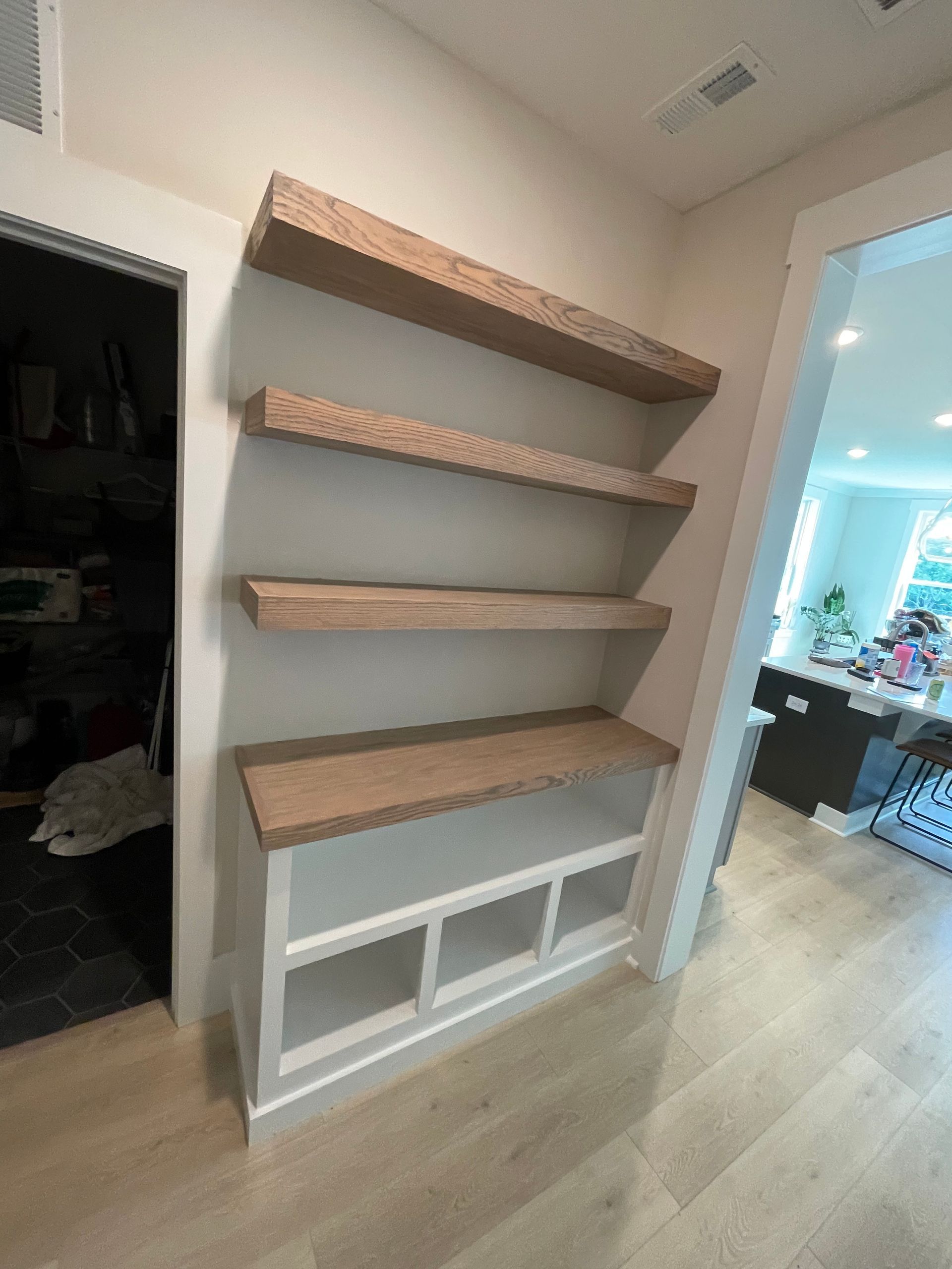 A bookshelf is sitting in a hallway next to a door.