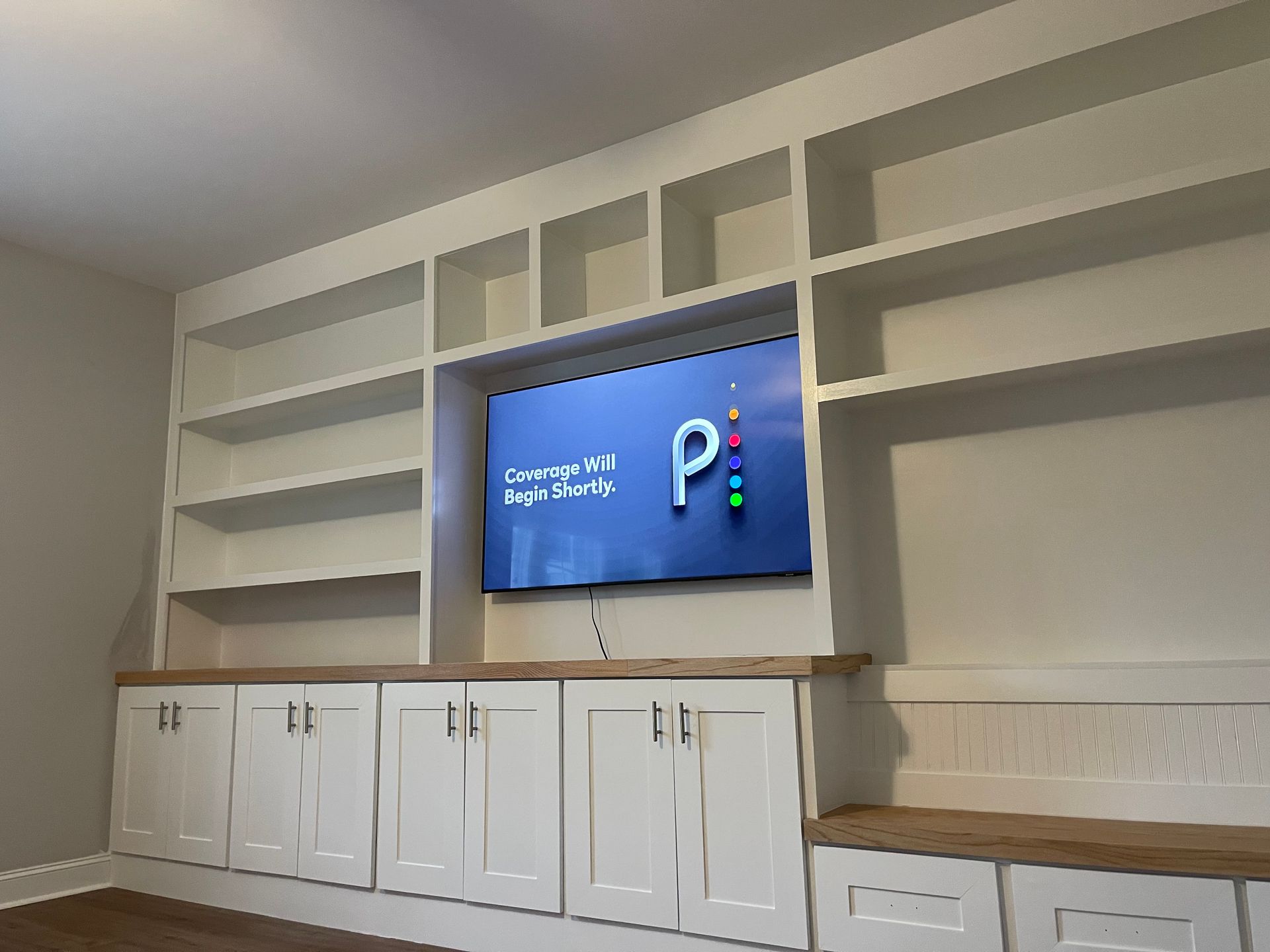 A living room with a flat screen tv mounted to the wall.