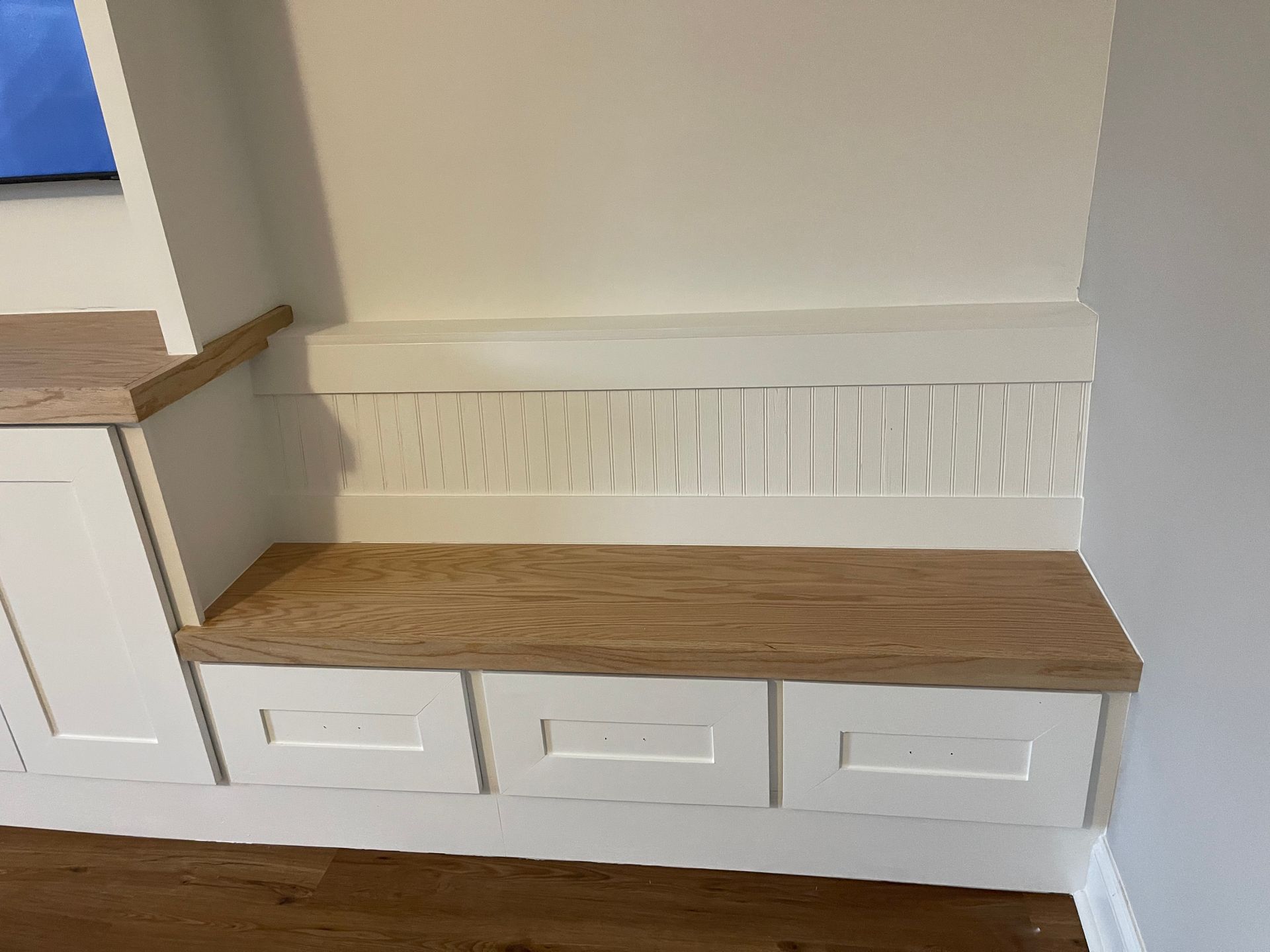 A wooden bench with drawers underneath it in a room.