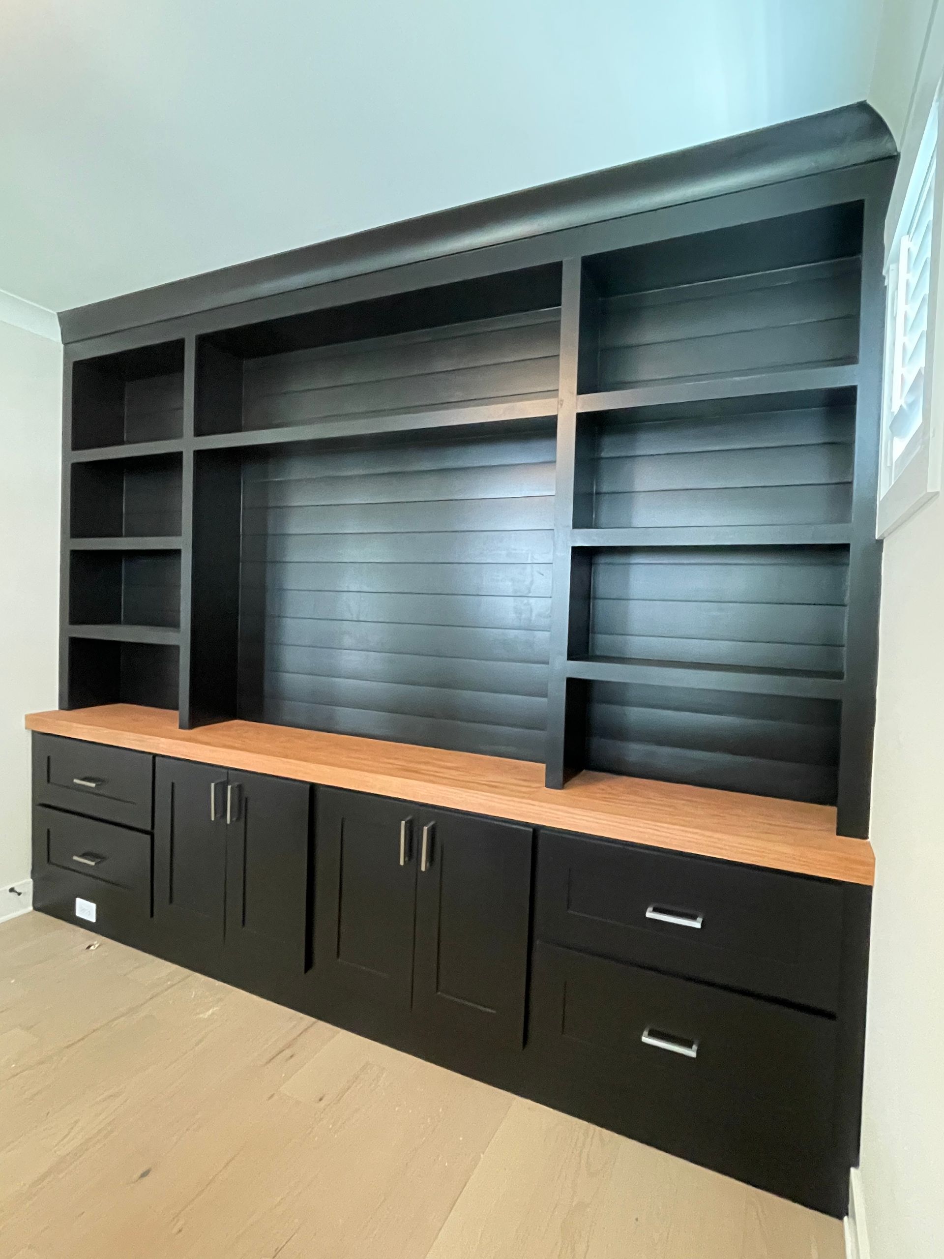 A large black cabinet with drawers and shelves in a room.