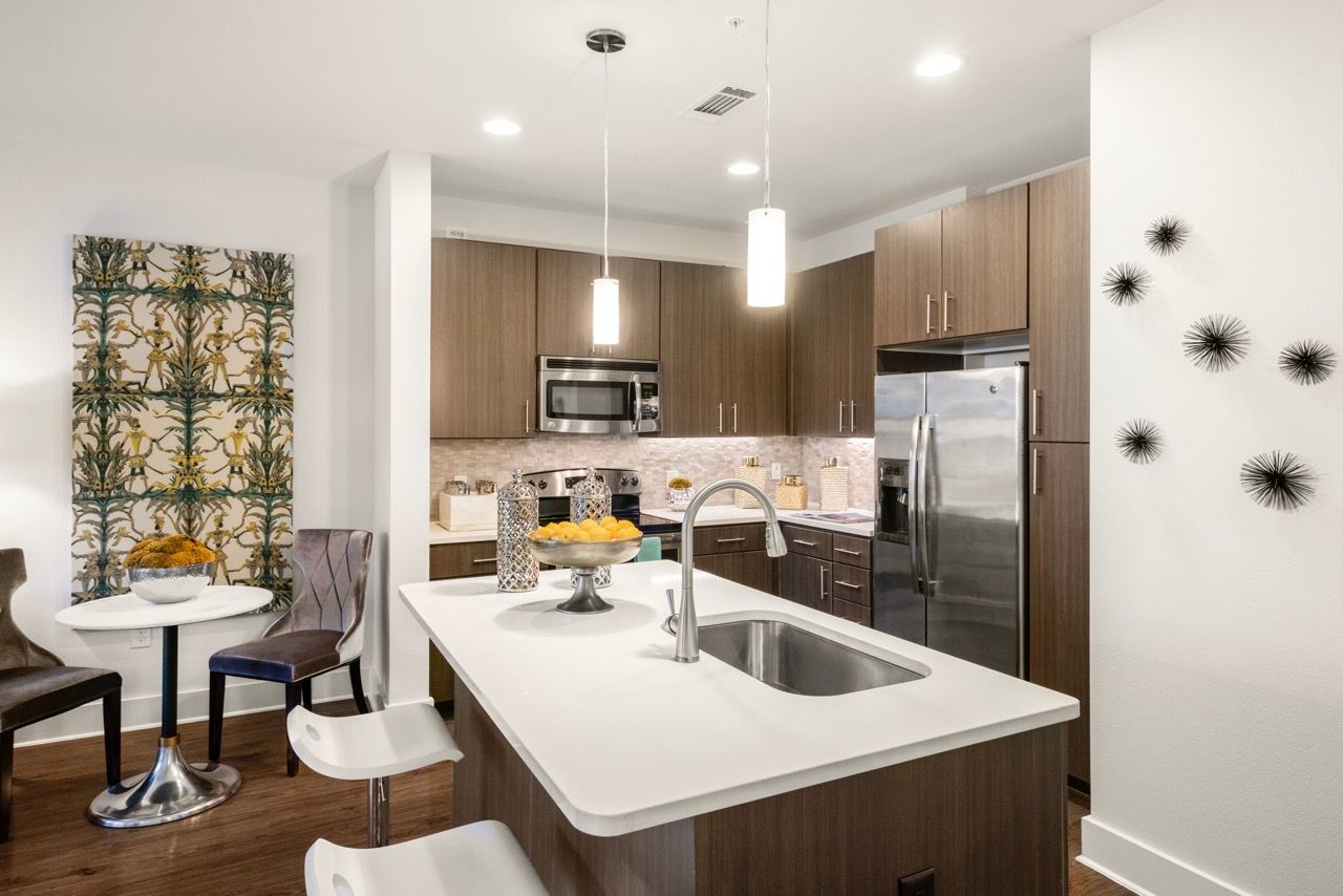 Open-concept kitchen with island, sink, and stainless-steel appliances.