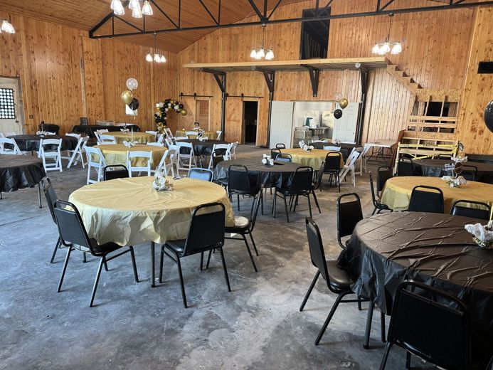 A large room with tables and chairs set up for a party.