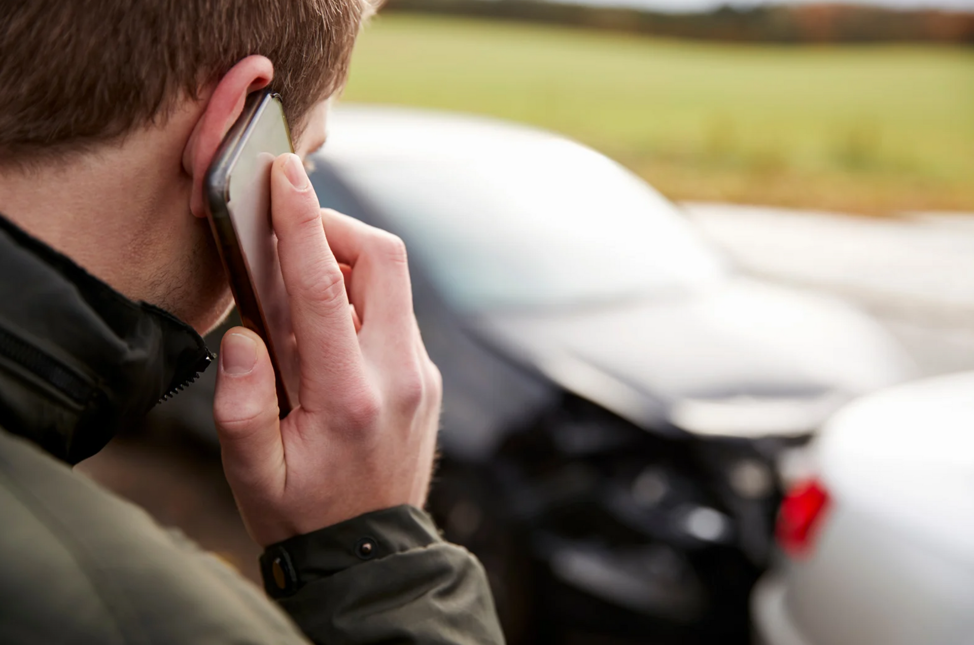Man calling on phone after being in car accident