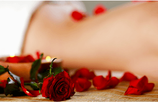 Someone having a massage with rose petals laid around them