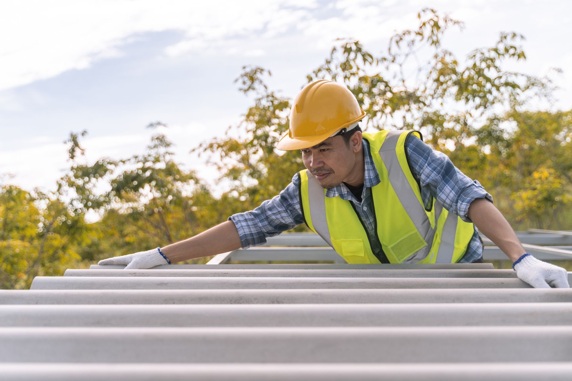 Roof repair contractor installing roof tiles at roof of house.