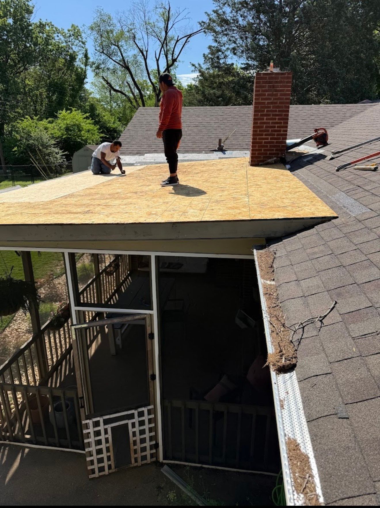 Person wearing work gloves hammering copper flashing onto a roof.