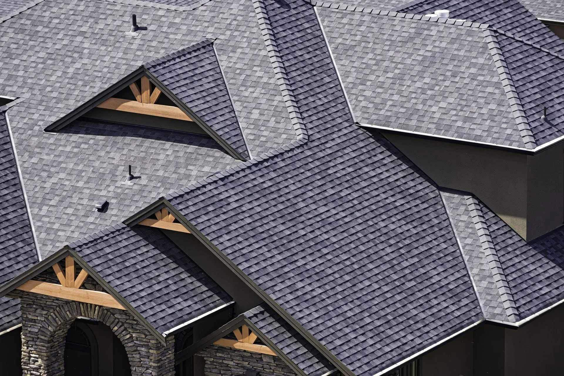 Gray asphalt shingle roof with multiple gabled sections; some with wooden beam accents.